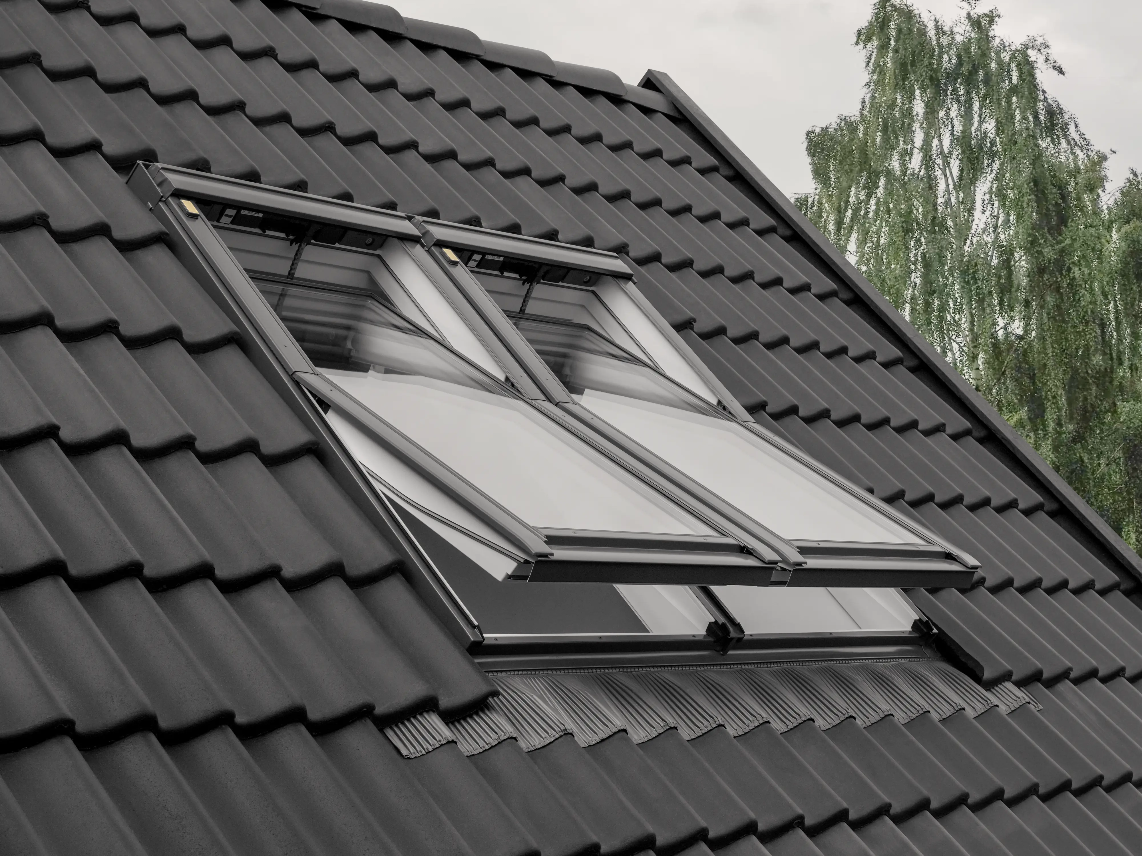 Neu eingebaute Velux Doppelkombination auf anthrazitfarbenem Ziegeldach im Bodenseeraum
